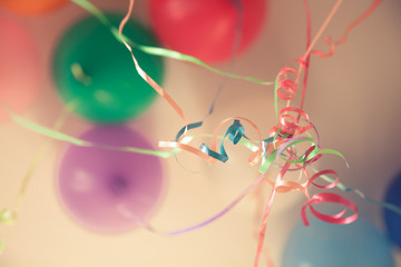 Vintage happy birthday party background with colourful tied ribbons and balloons in blue tone