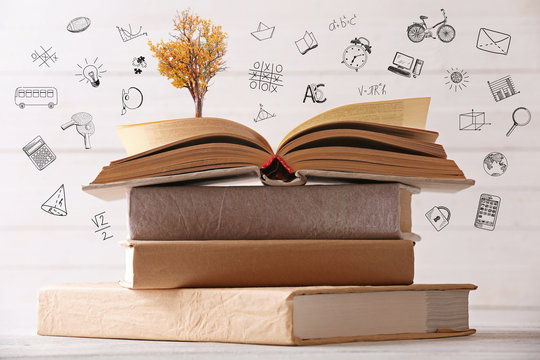 Stack of books with tree, closeup. Icons on blurred white background.
