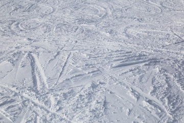 Traces from skiing on white snow.