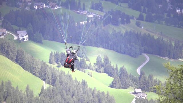Back view of paragliding over Italian alps.Slow motion