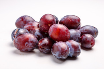 Fresh plums lying on a white plate