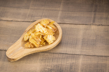 Dried fruit on wood background - pineapple
