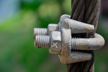 Big metal nut and bolt, marked with an X, locked on big metal wire