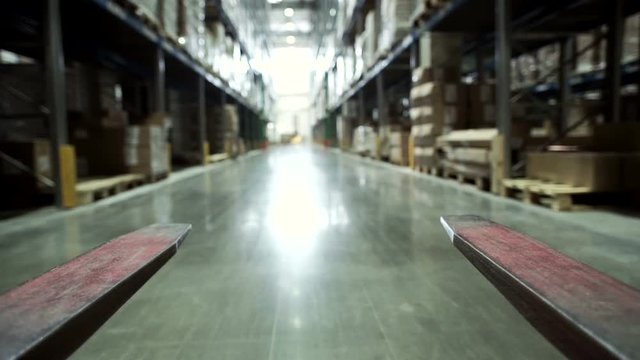 Forklift Trucks Move Between Large Metal Shelves at a Modern Warehouse