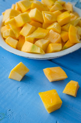 Autumn raw sliced pumpkin on blue wooden background