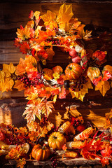 Still life consisting of wicker wreath, orange leaves, autumn be