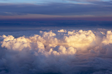 Aerial view of thick clouds over the land, the landscape. The texture of the scenic sky during sunset. 