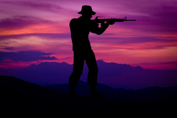Fototapeta na wymiar Silhouette of combat soldier circa Vietnam War Era. Set against nice purple sunset background.