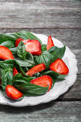 Strawberry salad with spinach and feta cheese on wooden table, closeup 
