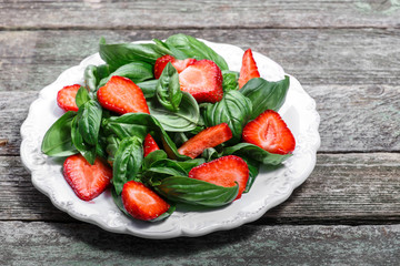 Strawberry salad with spinach and feta cheese on wooden table, closeup 
