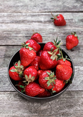 Sweet ripe strawberries in plate on wooden table, selective focus, top view