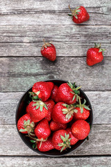 Sweet ripe strawberries in plate on wooden table, selective focus, top view