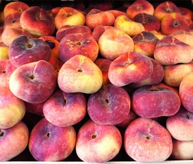 Fresh flat donut peaches at a farmers market