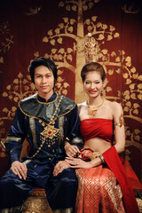 Thai woman and man in dressing traditional costume sit  in thai old house style.