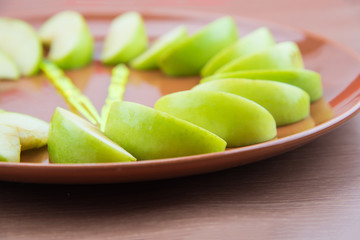 Green apple slice on orange plate.