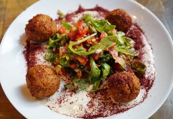 A plate of falafel balls with salad