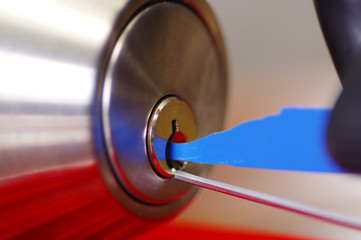 Closeup hands of locksmith using pick tools to open locked door