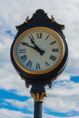 Fototapeta na wymiar Classic Street Clock on a Warm Summer Day Close Up
