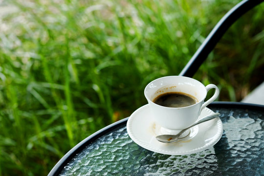 relaxing with hot black americano coffee Serve in white cup in garden in the afternoon 