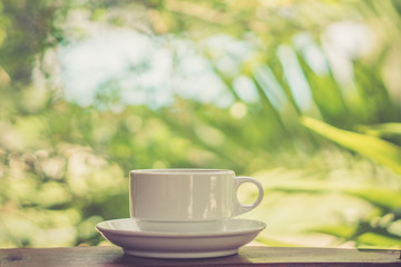 Retro style or Vintage Style, Black Coffee cup Put on a stump or wood table in the garden sunny morning.
