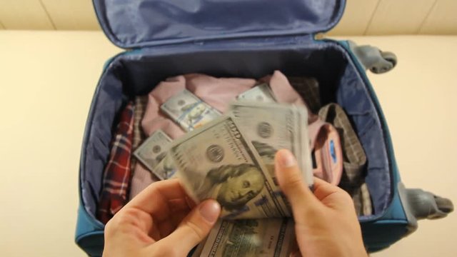 man counts money out of a suitcase. I am going on holiday