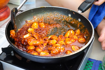 Chef cooking Thai style food with mushroom
