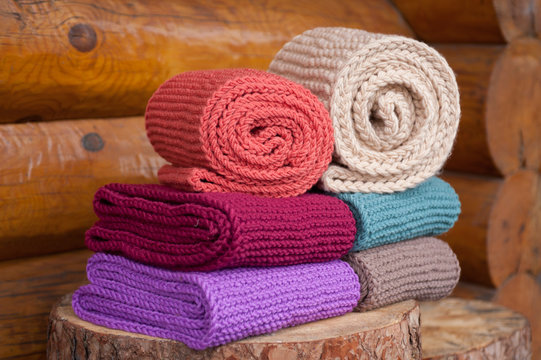 Six roll knitted scarf on wooden background