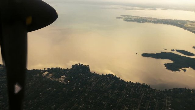 View from Inside Airplane of River and Land during Sunset