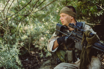 Naklejka premium Army sniper during the military operation in the mountain. 