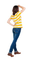 back view of standing young beautiful  brunette woman in yellow t-shirt. girl  watching. Rear view people collection.  backside view of person.  Isolated over white background.