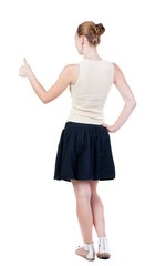 Back view of successful woman thumbs up. Rear view people collection. backside view of person. Isolated over white background. slender blonde in a dress shows hitchhiking