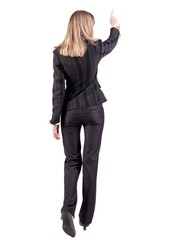 Back view of  business woman walking and pointing. young businesswoman in black suit. Rear view people collection.  backside view of person.  Isolated over white background.