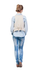 Obraz premium back view of standing young beautiful blonde woman in brown vest. girl watching. Rear view people collection. backside view of person. Isolated over white background.