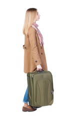 Back view of woman with suitcase looking up. Standing young girl. Rear view people collection.  backside view of person. Isolated over white background. Pretty girl in a striped dress stands with a