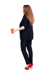 Rear view of a young business woman drinking coffee or tea while relaxing.  Young girl in suit.  Rear view people collection.  backside view of person.  Isolated over white background.