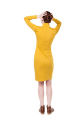 Back view of shocked woman in dress. upset young girl. Rear view people collection.  backside view of person.  Isolated over white background. Girl in mustard simple pain her head in her hands.