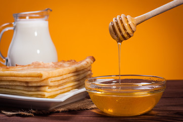 Fresh honey with a Stack of blinis or crepes