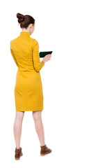 back view of standing young beautiful  girl with tablet computer in the hands of. girl  watching. Rear view people collection.  backside view of person.  Isolated over white background.