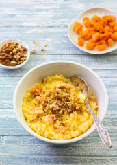 Corn porridge with pumpkin, honey and walnuts on a blue wooden background