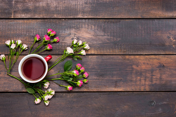 Cup of coffee with roses, top view