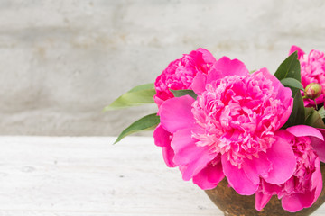 bouquet of pink peony in an old clay pot closeup