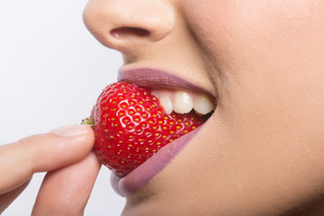 female lips eating red strawberry