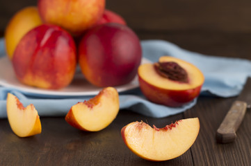 Naklejka na ściany i meble Slice of nectarine and whole fruits on a wooden table.