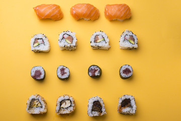 Various kinds of sushi food served on yellow blackground