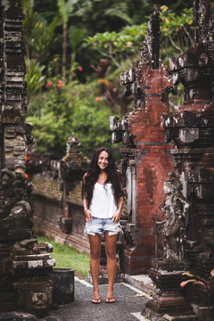 Woman with long black hair surrounded by an old Balinese architec