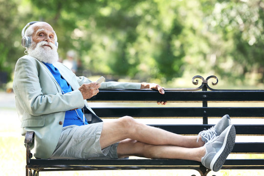 Elderly man listening to music in a park
