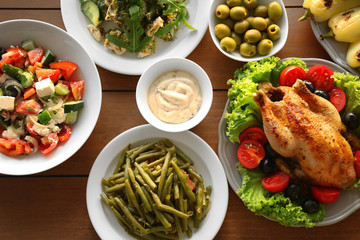 Plates with different salads and meat on table