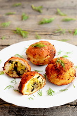 Fried meat balls stuffed with cheese and fried mushrooms. Stuffed meat balls on a plate and on wooden background. Home recipe. Closeup 