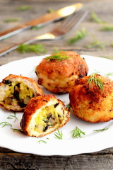 Fried turkey meat cutlets stuffed with cheese and fried mushrooms on plate on wooden background. Home cutlets prepared from minced turkey meat. Closeup