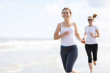 Two women running on beach